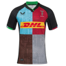 The Harlequins 24/25 Pro Home Jersey by Castore features multi-color panels with black sleeves, bold geometric patterns, a DHL chest logo, and the Harlequins crest on the left—official 2024/25 home kit.