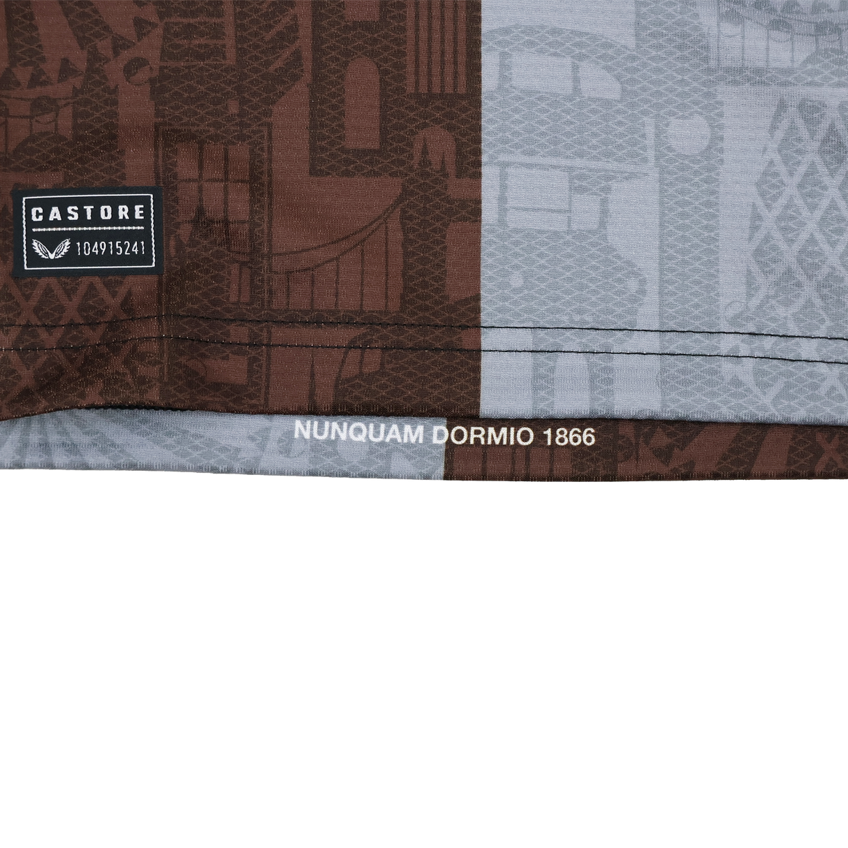 Close-up of the Harlequins 24/25 Pro Home Jersey by Castore fabric, featuring a "CASTORE" label with code, patterned design, and "NUNQUAM DORMIO 1866" text printed near the hem.