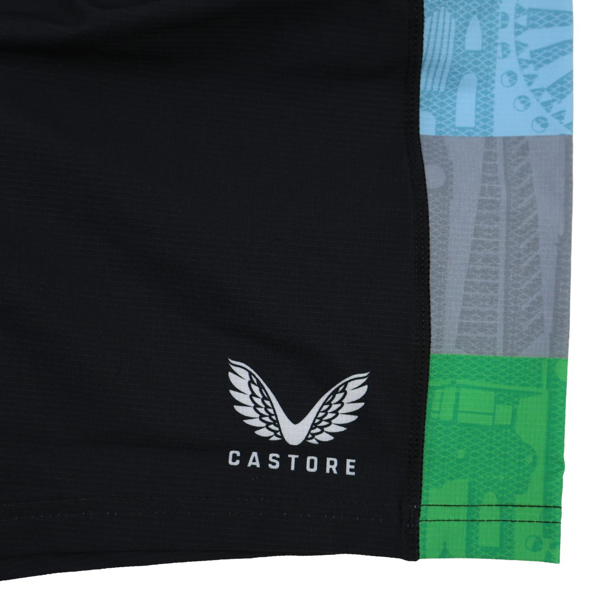 Close-up of black Harlequins 24/25 Pro Home Short by Castore with white logo and name, featuring vertical blue, gray, and green patterned stripes on the right—part of the professional rugby teamwear collection.