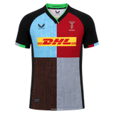 The Harlequins 24/25 Replica Home Jersey by Castore features a black collar and sleeves, a multicolored quartered front, and the DHL sponsor logo on the chest.