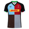 The Harlequins 24/25 Replica Home Jersey by Castore features a black collar and sleeves, a multicolored quartered front, and the DHL sponsor logo on the chest.