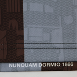 Close-up of the Castore Harlequins 24/25 Replica Home Jersey features "NUNQUAM DORMIO 1866" on the hem and a brown and gray geometric architectural pattern.