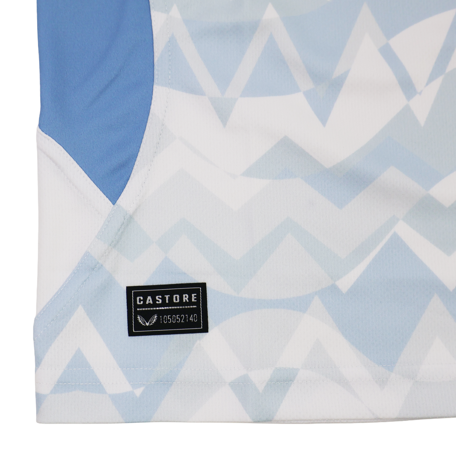 Close-up of the Leinster 24/25 Replica Away Jersey by Castore, featuring a blue and white zigzag pattern, solid blue side panel, and a black Castore label near the hem.