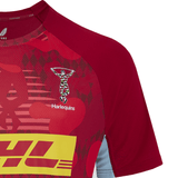 The Harlequins 24/25 Matchday Tee by Castore is a red rugby jersey ideal for matchday, adorned with DHL logos, geometric patterns, and crafted from textured, moisture-wicking fabric.