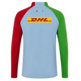 The Harlequins 24/25 Matchday 1/4 Zip Midlayer by Castore features a light blue back, red right sleeve, green left sleeve, and a yellow DHL logo on the upper back.