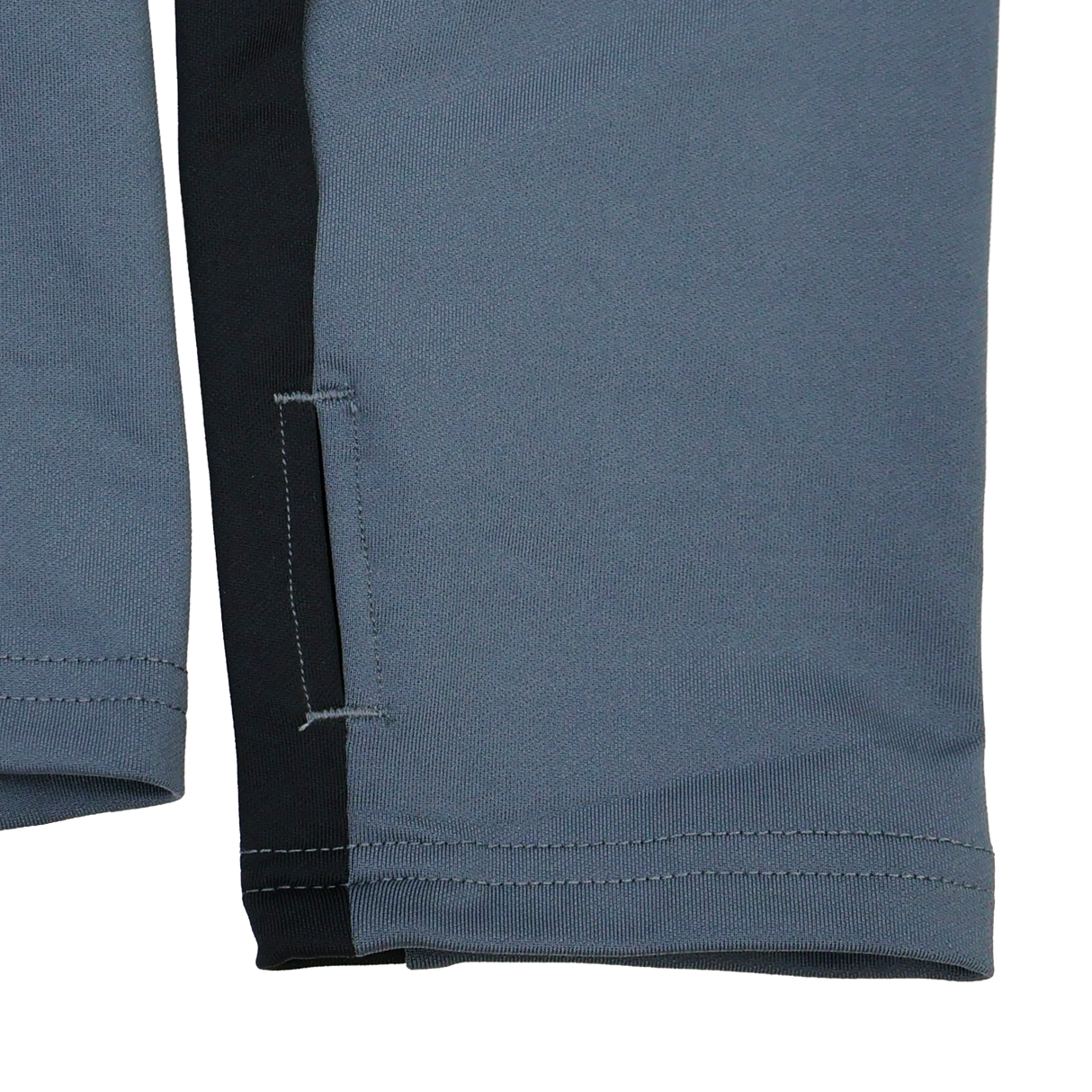 Close-up of gray and black pant legs with stitching and a side slit—ideal to pair with your Castore Bath 24/25 Pro Players 1/4 Zip Midlayer for a complete sporty look.
