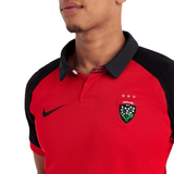 The man is wearing a red and black Nike RC Toulon Home Rugby Jersey 23/24.