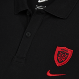 Close-up of the Nike RC Toulon 25/26 Pique Polo, a black shirt with an embroidered red RC Toulon crest and red Nike swoosh on the chest.