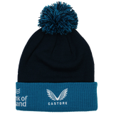 The Leinster Bobble Beanie 24/25 by Castore is a navy blue hat with a teal cuff and pom-pom, featuring the embroidered crest and white Castore logo on the cuff.