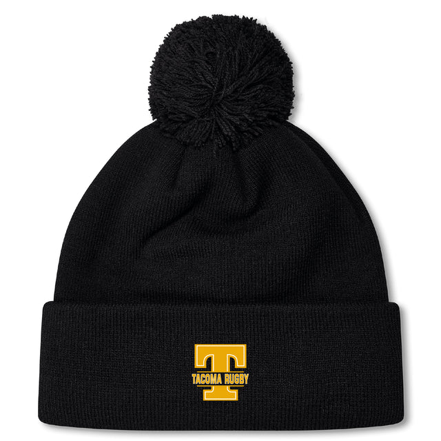 Stay warm in the Tacoma Tsunami Rugby Pom Pom Beanie by EMB Canterbury. This black knit, fleece-lined beanie features a pom-pom, a bold yellow "T," and "TACOMA RUGBY" embroidered on the brim—ideal for dedicated rugby fans.