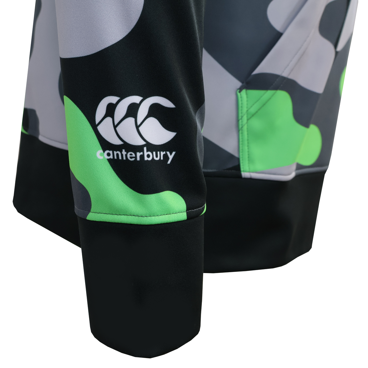 Close-up of the CANTERBURY MID-LAYER SUBLIMATE HOODIE - MENS by Teamatical, featuring a green, black, and gray camo sleeve with a white Canterbury logo—ideal for your next team or midweight hoodie design.