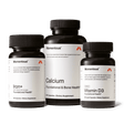 Three bottles of Momentous The Women’s Three™ by Momentous are shown, featuring Iron+, Calcium, and Vitamin D3 supplements as a daily health system for women against a plain background.