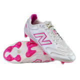 A pair of New Balance 442 Elite FG v3 soccer cleats in Sea Salt/Pink Heat, featuring pink accents and studs with the New Balance logo, displayed on a white background.