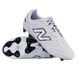 A pair of New Balance Wide 442 Elite FG v3 soccer cleats in white/black—one upright and one showing the sole and studs—offer wide-fit comfort and reliable firm ground performance for players.