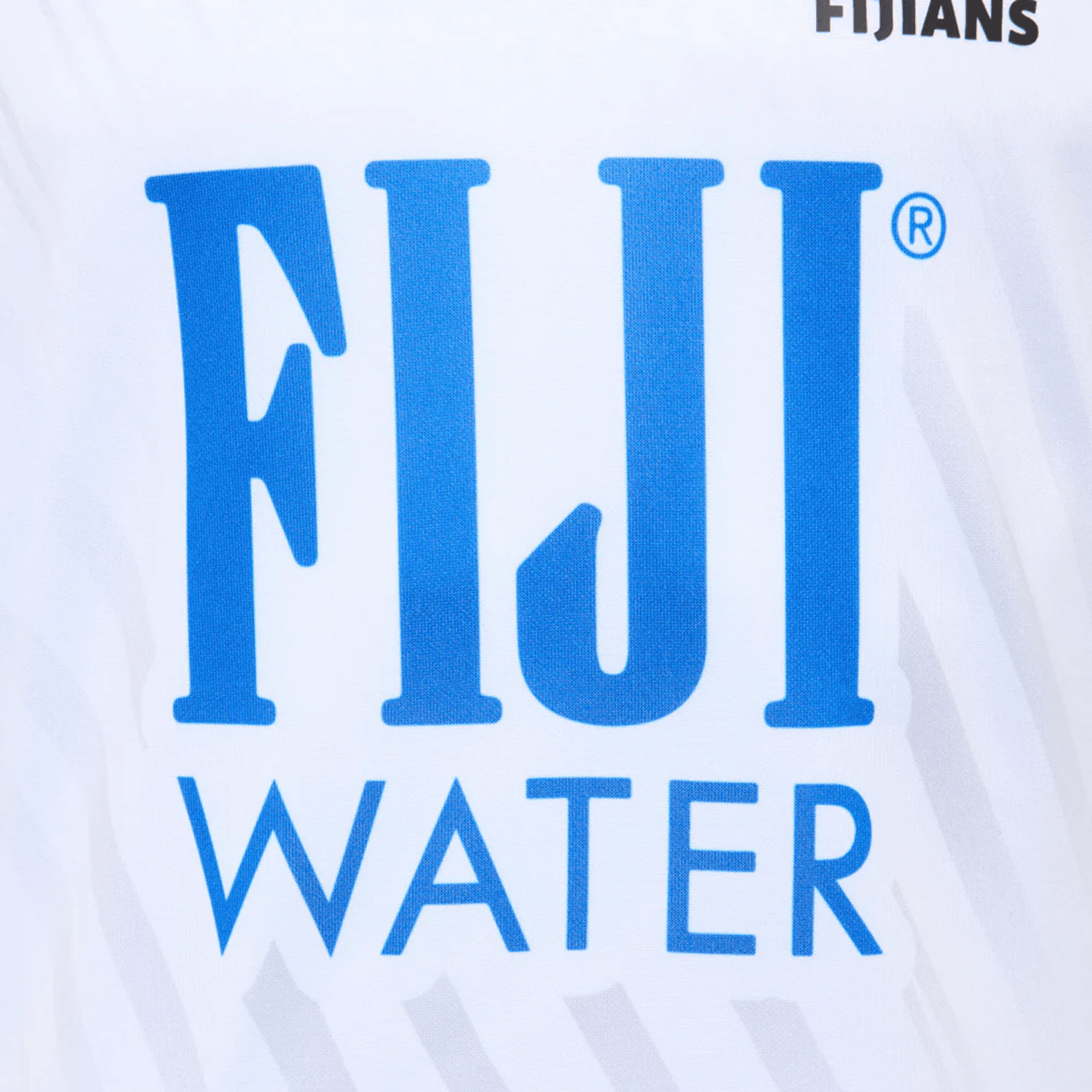 Close-up of the Fiji 25/26 Replica Home Jersey by Umbro, a white shirt with the blue "FIJI WATER" logo, partial "FIJIANS" text in the top right, and subtle Fijian masi art inspired by authentic Fiji jerseys.