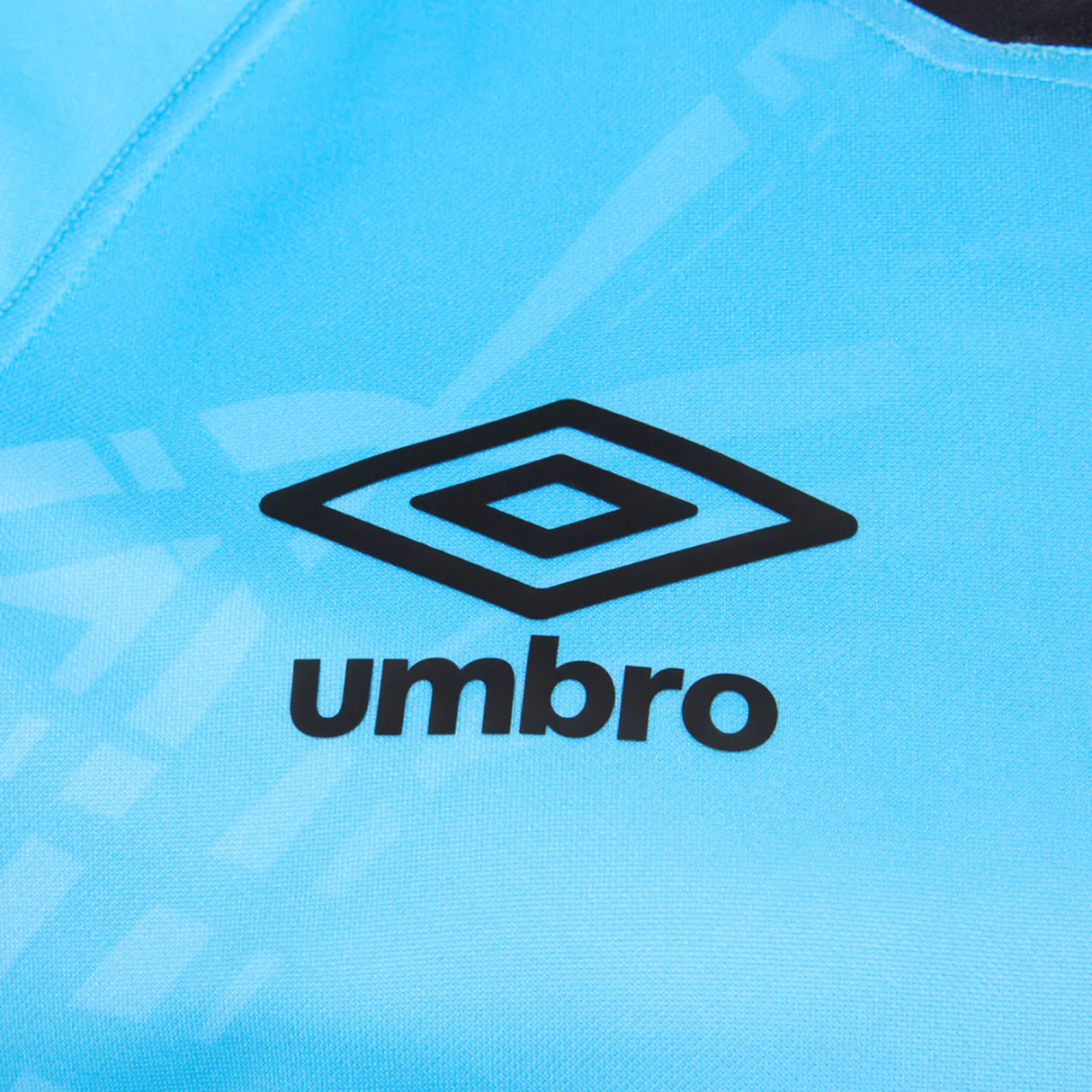 Close-up of the Fiji 25/26 Replica Away Jersey by Umbro, light blue with the black Umbro logo and name centered, and featuring subtle Fijian masi art details on its polyester athletic fit.