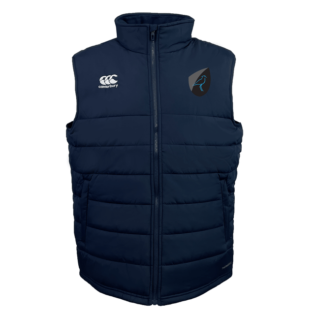 The Uruguay Shield Core Gilet by EMB Canterbury is a navy blue puffer vest with a high collar, featuring two logos on the chest and Thermoreg insulation for added warmth.