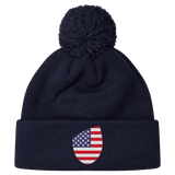 Just In: EMB Canterbury's USA Shield Pom Pom Beanie in navy blue, showcasing a cozy knit design with a playful pom-pom on top and featuring the USA Shield patch on the cuff.