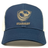 The EMB S&S Activewear USA Rugby Bronze Eco Trucker Hat features a gold logo and text on navy blue organic cotton, plus a breathable mesh back for eco-friendly comfort.