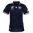 The Women's USA Rugby WRWC25 Replica Home Jersey by Macron features navy blue short sleeves, official logo, WRWC25 event patches, American flag on the sleeve, and white, red & blue trim on collar and cuffs.
