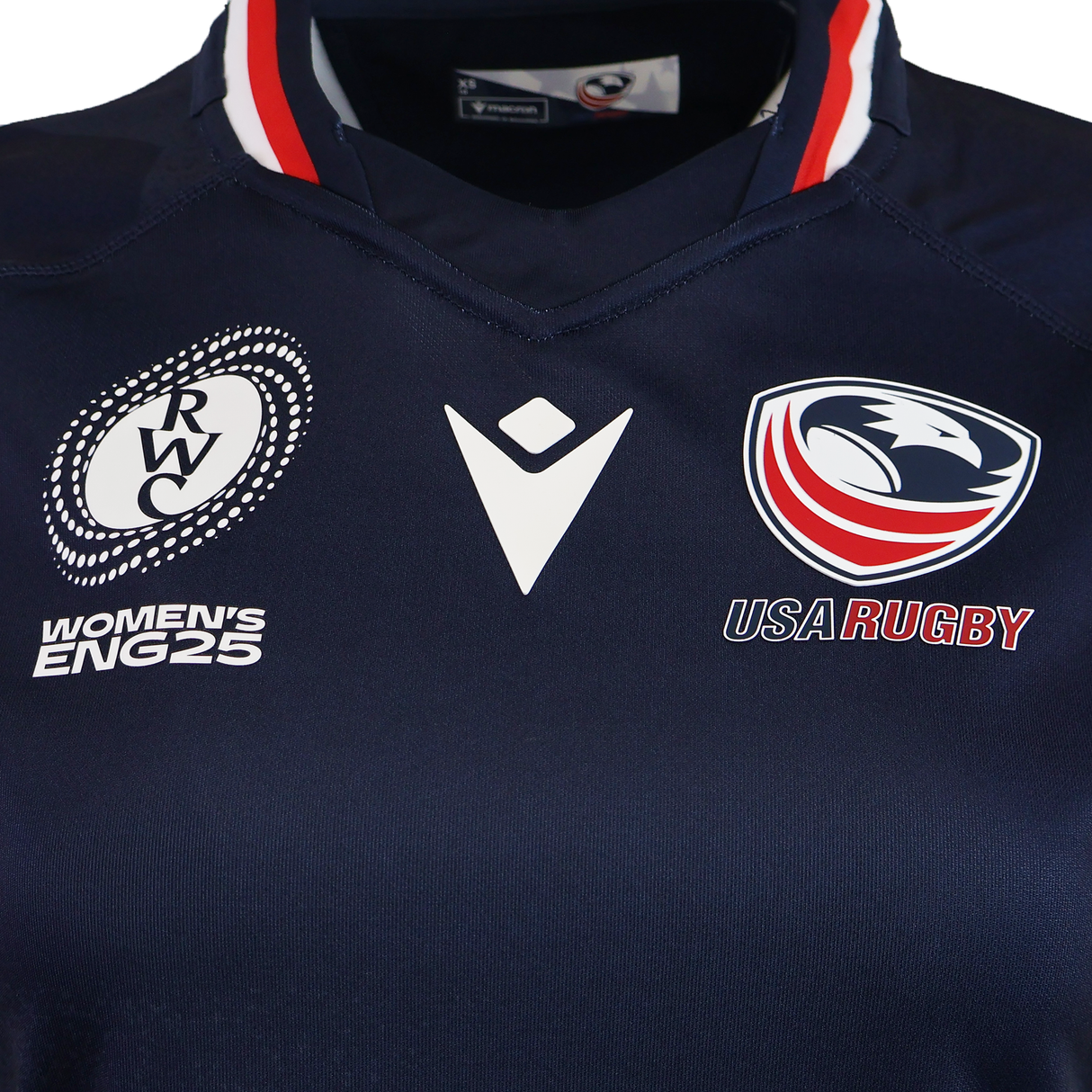The Women's USA Rugby WRWC25 Replica Home Jersey by Macron features a navy blue design with the ENG25 logo on the left, Macron rugby jersey logo in the center, and USA Rugby eagle emblem on the right.