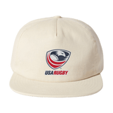 The EMB Weld USA Rugby Crest Brushed Cotton Cap is a stylish beige hat with an intricately embroidered USA Rugby logo, featuring an eagle and rugby ball on the front.