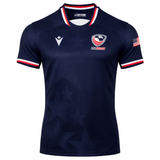 Show your support with the USA Rugby 24/25 Authentic Matchday Home Jersey by Macron—navy blue with white, red, and blue trim, USA Rugby logo, Macron branding, and an American flag patch. Ideal for fans and players alike.