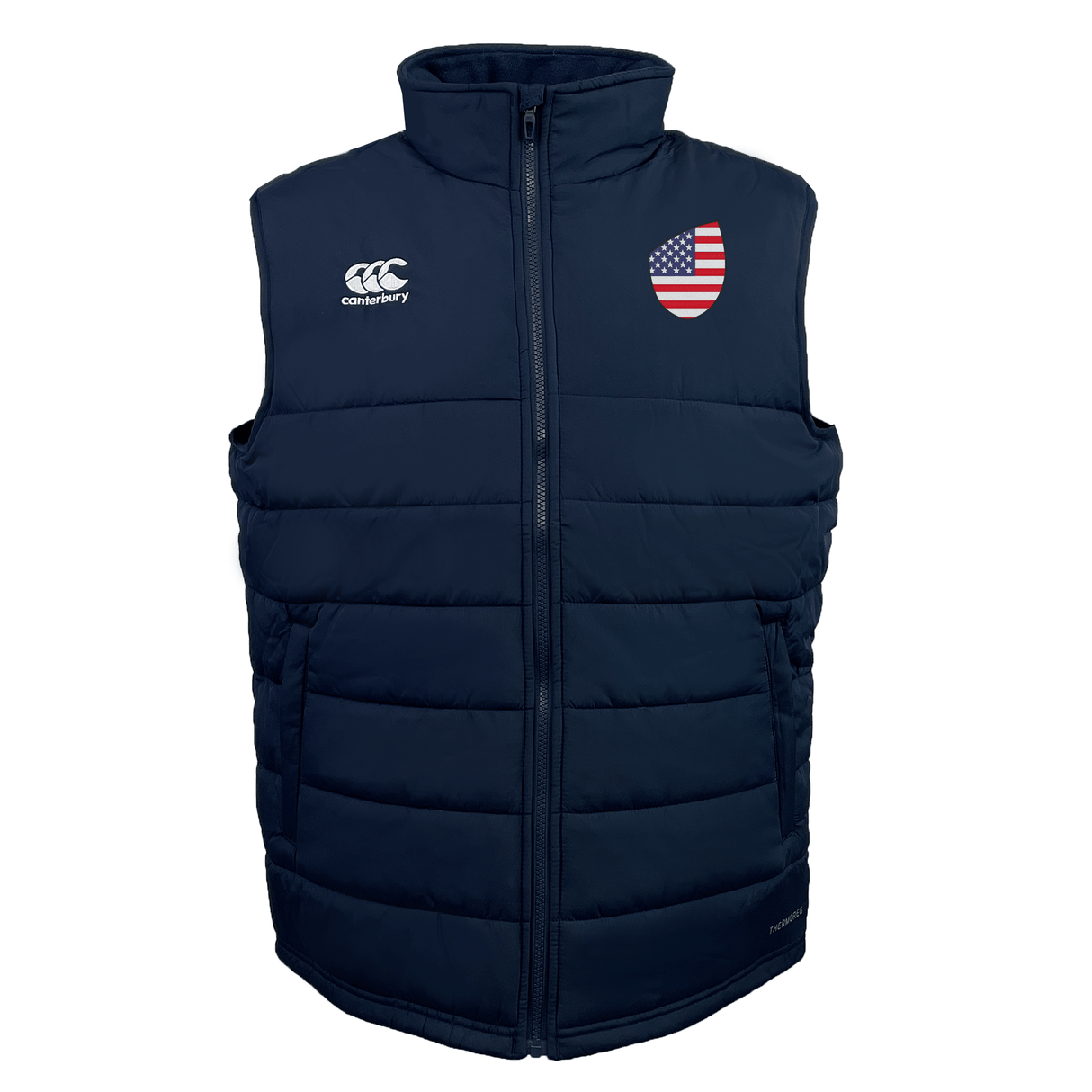 The USA Shield Core Gilet by EMB Canterbury is a navy blue puffer vest with an American flag patch on the left chest, a company logo on the right chest, Thermoreg insulation, and a front zipper.