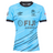 The Fiji 7's 25/26 Replica Away Jersey by Umbro features a light blue design with black collar and sleeve trim, palm logo, and bold blue and black diagonal lines.