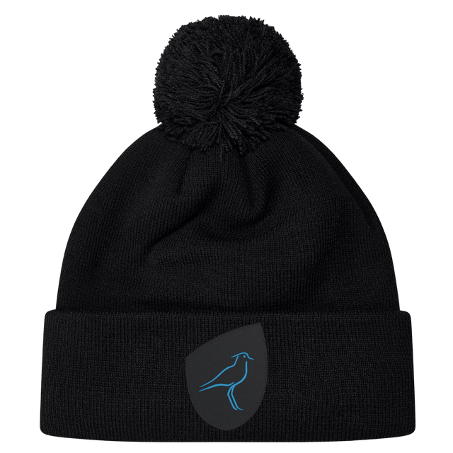 The Uruguay Shield Pom Pom Beanie by EMB Canterbury showcases a stylish black design with a striking blue bird logo on the front, combining fashion and warmth perfectly.