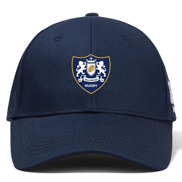 The Villanova Rugby Club Flexfit Drill Cap by EMB Canterbury features a navy blue design with an embroidered crest of two lions and a shield on the front panel.