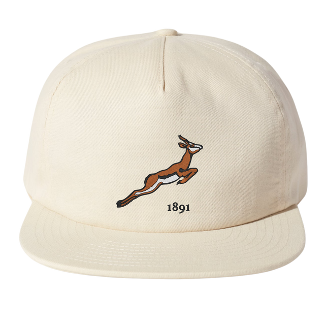The Nations of Rugby South Africa Vintage Brushed Cotton Cap by EMB Weld is a beige baseball cap with an embroidered leaping antelope and "1891" on the front, offering nostalgic flair and sporty elegance.