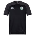 The Woodlands Youth Vapodri Evader Jersey by EMB Canterbury is a black short-sleeve rugby jersey with a round neck, Canterbury logo on the right chest, wolf paw emblem on the left, and moisture-wicking tech for comfort.