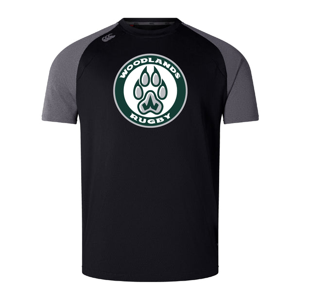 The Woodlands Youth Elite Training Tee by WRS Canterbury features black and gray short sleeves, a bold "Woodlands Rugby" chest logo with paw print, and is made from lightweight Vapodri fabric for comfort and performance.