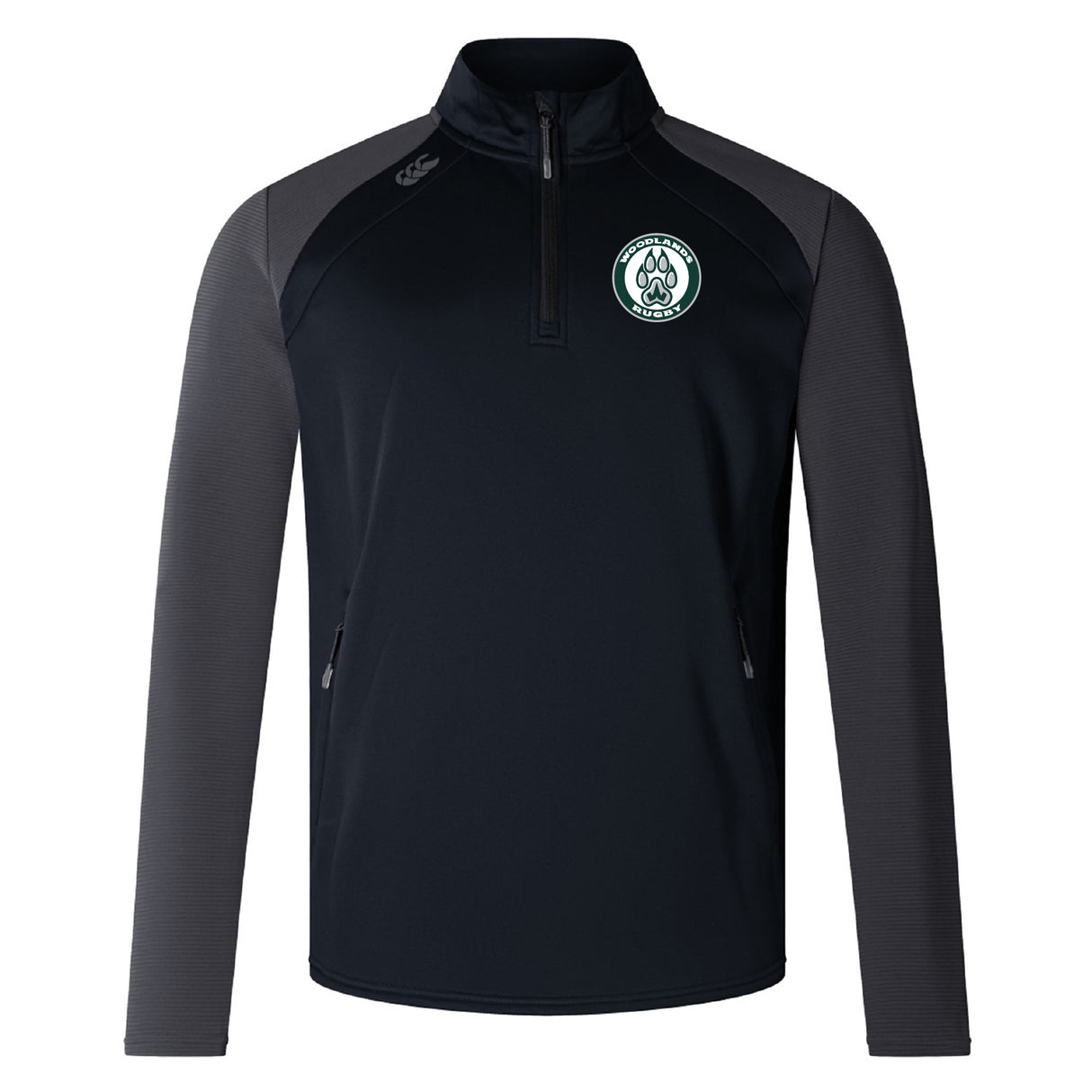 The Woodlands Youth Elite 1/4 Zip Top by EMB Canterbury is a black and dark gray athletic jacket with a zip collar, side pockets, and a green and white embroidered chest logo—ideal as a lightweight training top.