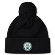The Woodlands Youth Pom Pom Beanie by EMB Canterbury is a black, fleece-lined hat with a pom-pom and a "Woodlands Rugby" paw print logo patch—perfect for keeping warm at chilly rugby games.