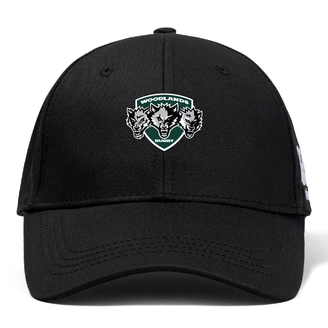 The Woodlands Youth Wolfpack Flexfit Drill Cap by Canterbury features an embroidered "Woodlands Rugby" logo with three wolf heads on the front. Brand: EMB Canterbury. Color: black.
