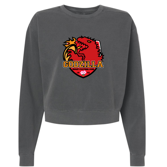 The EMB S&S Activewear Godzilla Rugby Football Club Women’s Garment-Dyed Mid-Length Crewneck Sweatshirt is a dark gray, cropped sweatshirt featuring a red and gold “Godzilla Rugby Football Club” logo with a stylized dragon on the front.
