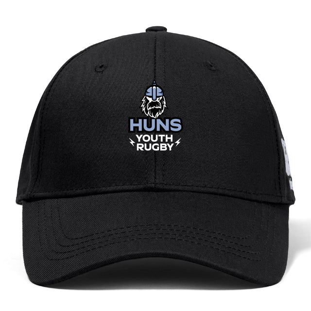 The Austin Huns Youth Rugby Flexfit Drill Cap by EMB Canterbury features a black design with the "Huns Youth Rugby" logo, including a Viking helmet and beard, and has a classic curved brim style.