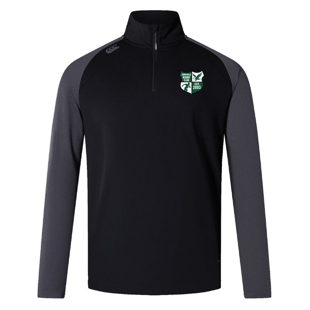 The Zionsville Rugby Club Elite First Layer by EMB Canterbury is a black long-sleeve quarter-zip pullover with dark gray sleeves, VapoDri tech for moisture control, and a green and white embroidered logo on the left chest.