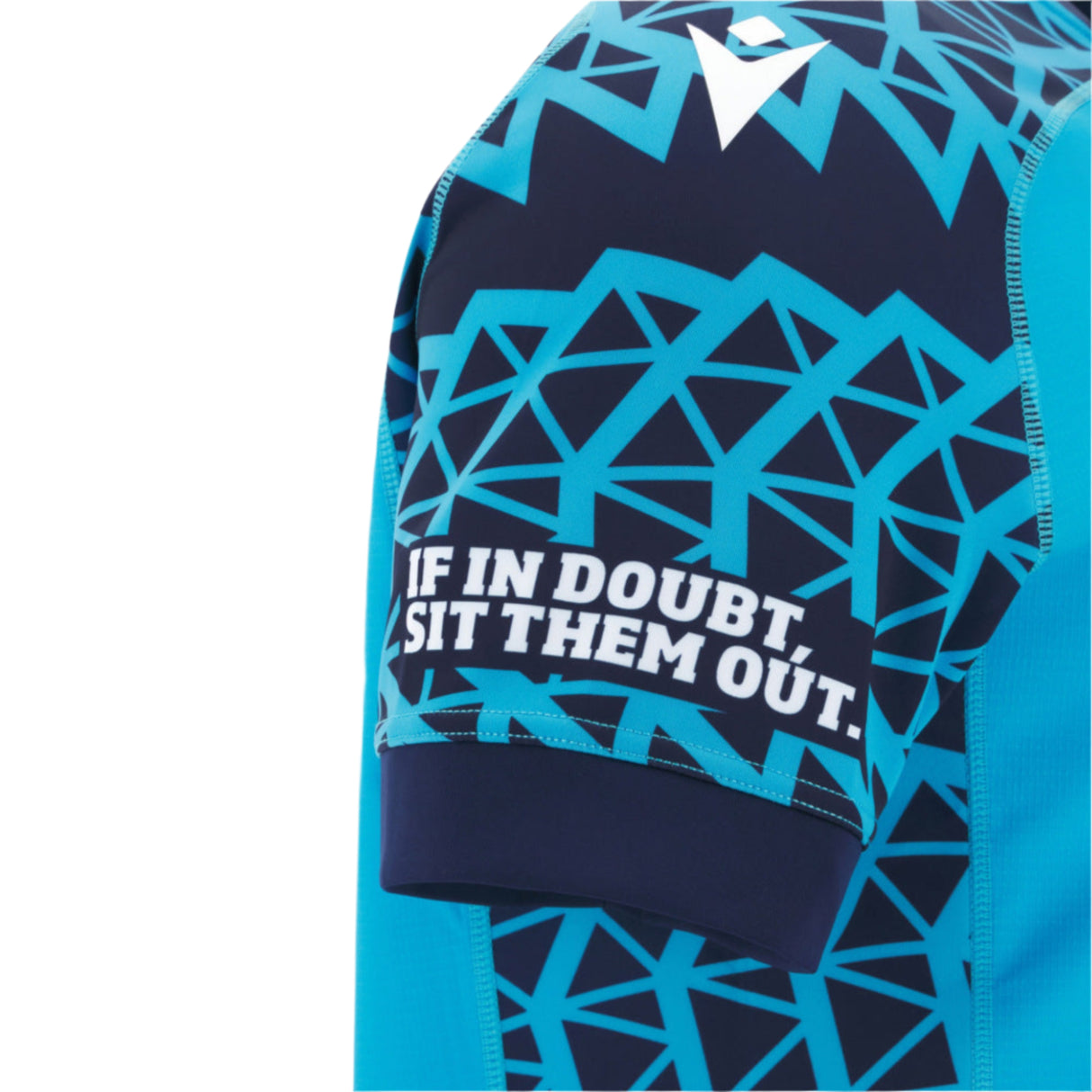 Close-up of the Macron Scotland 25/26 Sky Training Jersey sleeve, showing a blue geometric pattern and the text "IF IN DOUBT, SIT THEM OUT.
