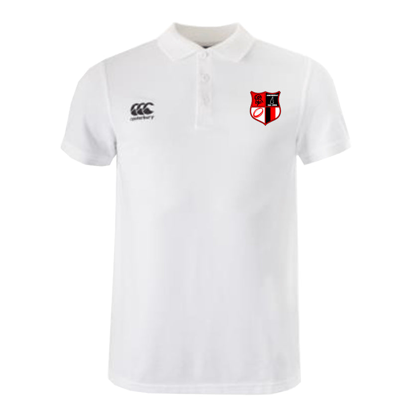 The Amoskeag Rugby Club Waimak Polo by EMB Canterbury is a white rugby polo featuring a red and black shield emblem, made from a comfy cotton-polyester blend. It has a button-up collar and displays the small Canterbury logo on the left.