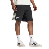Wearing a white shirt, white crew socks, and white adidas sneakers with black stripes, this person completes their look with All Blacks 26/27 Leisurewear Shorts by adidas.