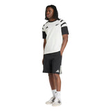 Person wearing a white and black T-shirt, adidas All Blacks 26/27 Leisurewear Shorts in black with white stripes, white socks, and white sneakers, standing against a plain white background.
