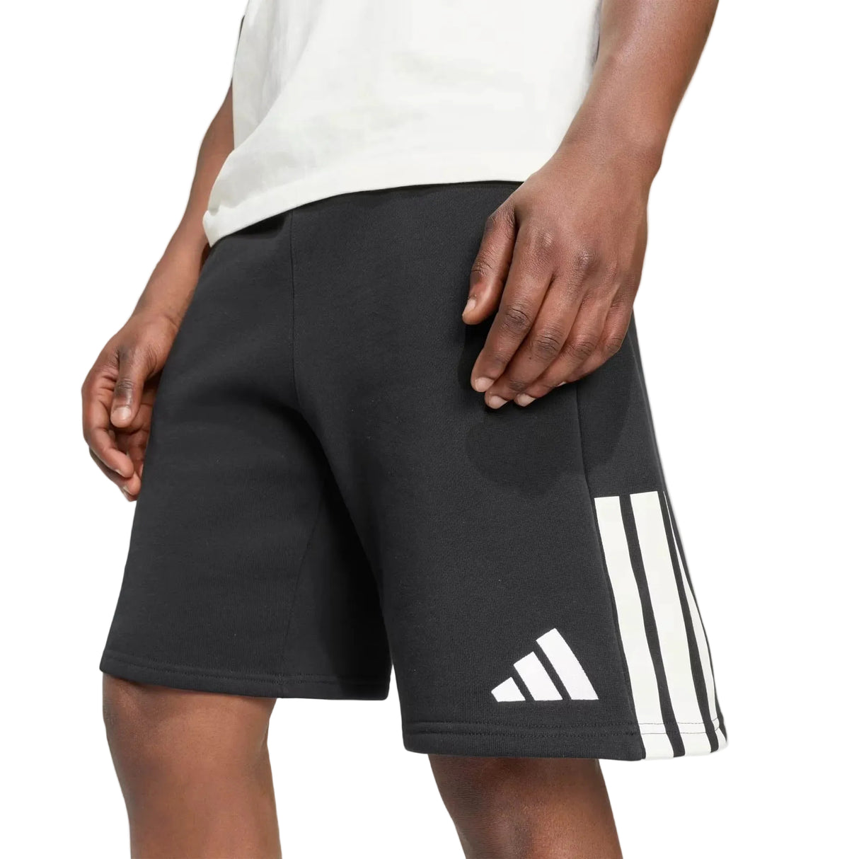 Person wearing adidas All Blacks 26/27 Leisurewear Shorts, featuring black fabric with signature white stripes and adidas branding, standing with hands relaxed by their sides. Only the lower torso and upper legs are visible.