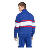 A person wearing the adidas France FFR 26/27 Travel 1/4 Zip Sweatshirt, featuring red and white stripes on the back, stands facing away from the camera.