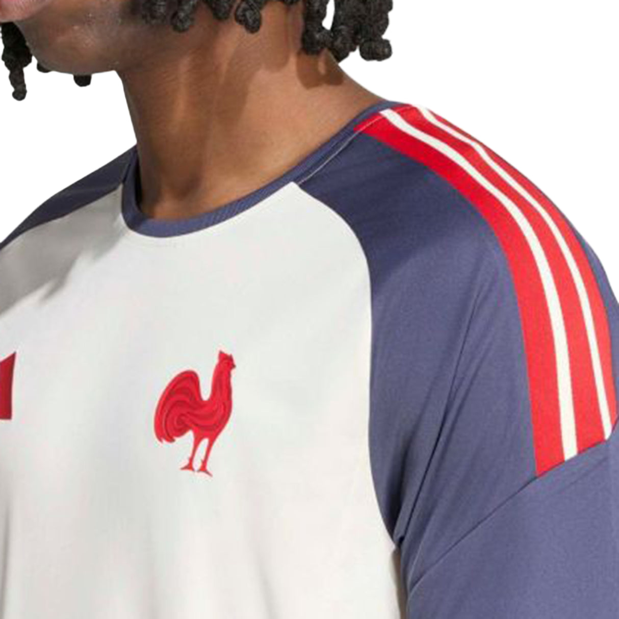 A person wearing the adidas France FFR 26/27 Performance T-Shirt, featuring a white and navy design with red shoulder stripes and a red rooster emblem on the chest, captures the timeless style inspired by the official French national rugby team.