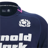 A close-up of the Scotland SRU 25/26 Replica Home Jersey by Macron, showing its navy blue design with the team’s thistle logo, white sponsor text, and pink shoulder detailing on this official home shirt.