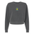 The EMB S&S Activewear Women's Blackthorn Rugby Mid-Length Crewneck Sweatshirt is cropped, garment-dyed charcoal gray, and displays a small colorful crest logo on the chest against a white background.