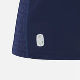 Close-up of the lower section of the Women's Scotland 25/26 Replica Home Jersey by Macron, featuring a small eco-friendly label and “SCOTLAND” text pattern along the side.